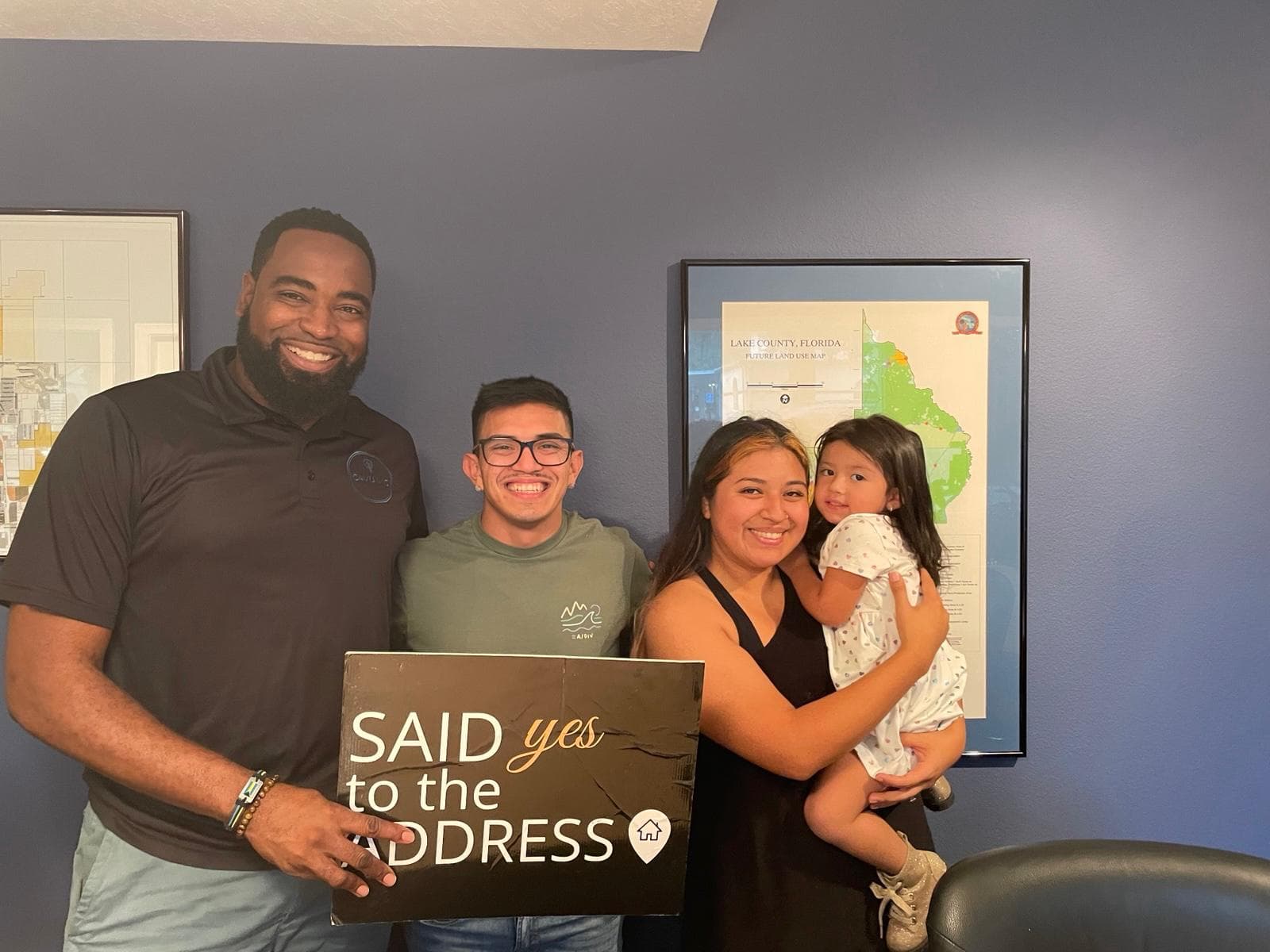 Paul with a young family holding a Said Yes to the Address sign